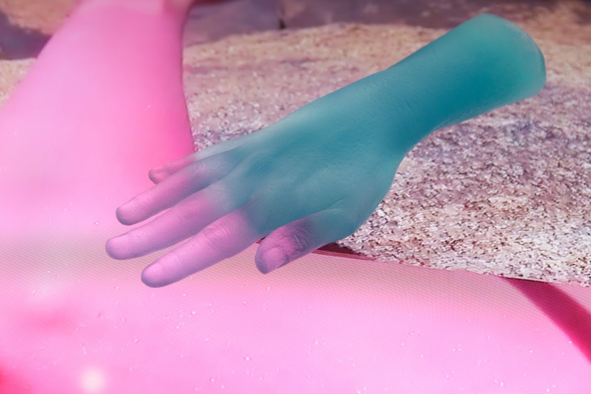 a blue and pink hand being displayed on a pink and rocky background