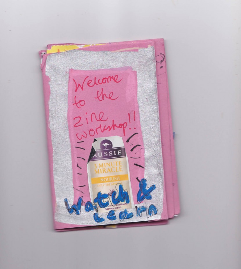 A zine with a pink cover, with a silver boarder, titled "welcome to the zine workshop" an AUSSIE shampoo label is stuck onto it with the words "watch and learn" written under