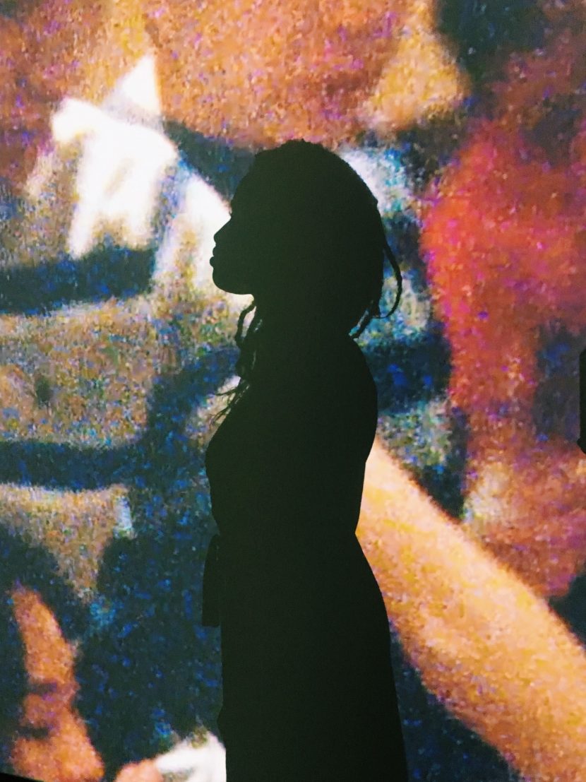 a silhouette in front of a grainy photo of children