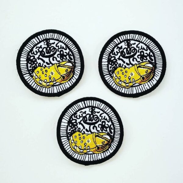 three patches with black and white backgrounds and a yellow croc