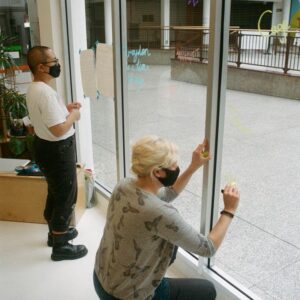 two people writing on a window