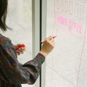 Someone drawing a building on a window