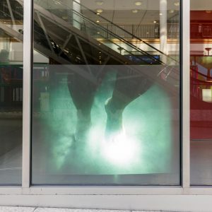 a projection displaying someone walking in the window