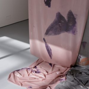 Detail of hanging pink fabric with purple prints