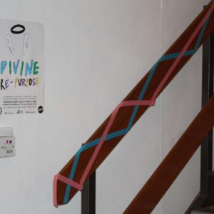 a poster advertising a upcoming exposition next to some decorated wooden stairs