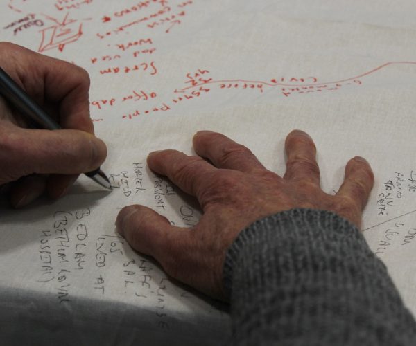 a workshop participant writing ideas on a large sheet of fabric