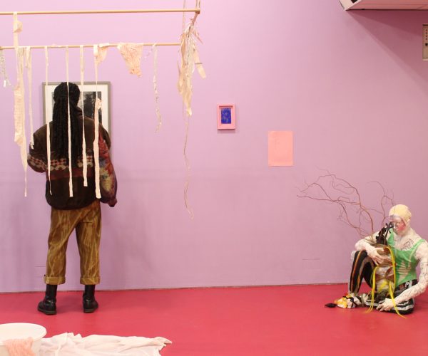 a photograph of exhibition visitors viewing artwork in the show.